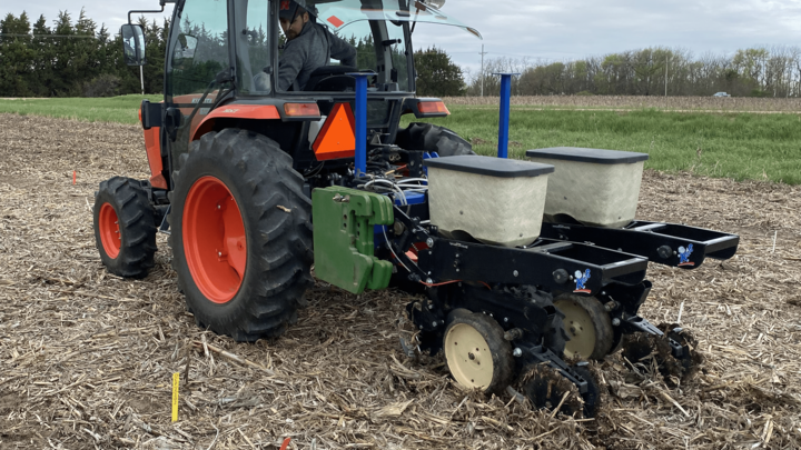 Ricardo Fuchs, an agronomy intern from Brazil, drives a tractor to plant seeds for research.